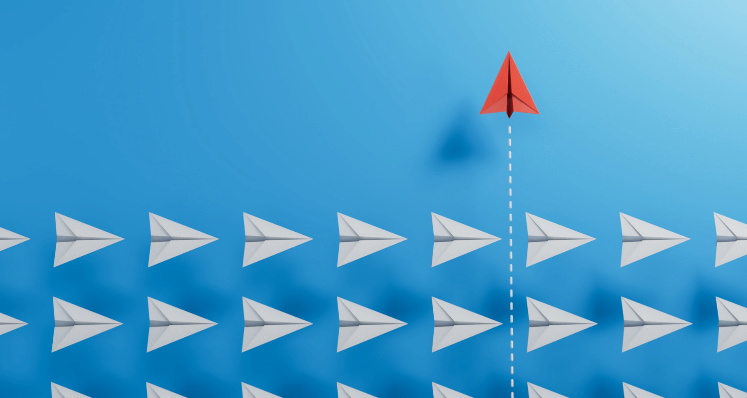 Red paper plane flying upwards white plane flying horizontal